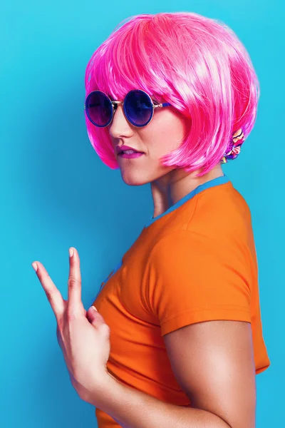 Kvinna pop porträtt klädd i rosa peruk och gör V-tecknet — Stockfoto
