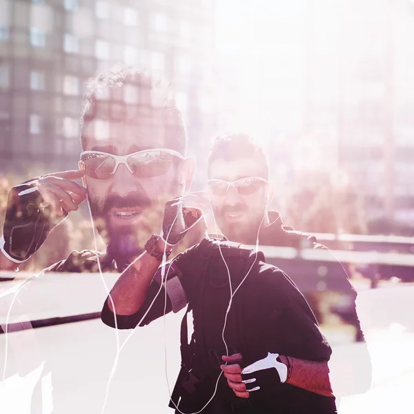 Double exposure of cyclist in the city wearing sunglasses — Stock Photo, Image