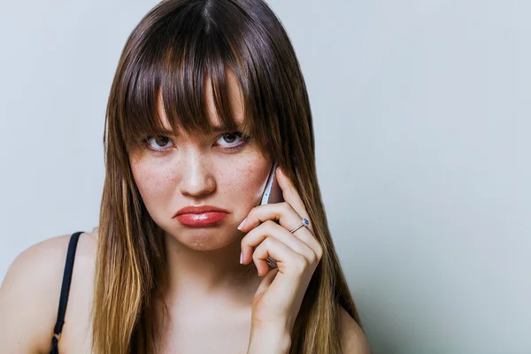 Söt flicka pratar i telefon och bli besviken — Stockfoto
