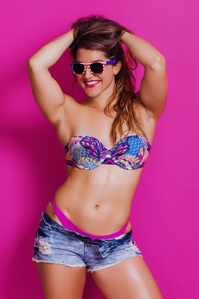 Retrato femenino alegre del culturista que usa bikini y gafas de sol — Foto de Stock