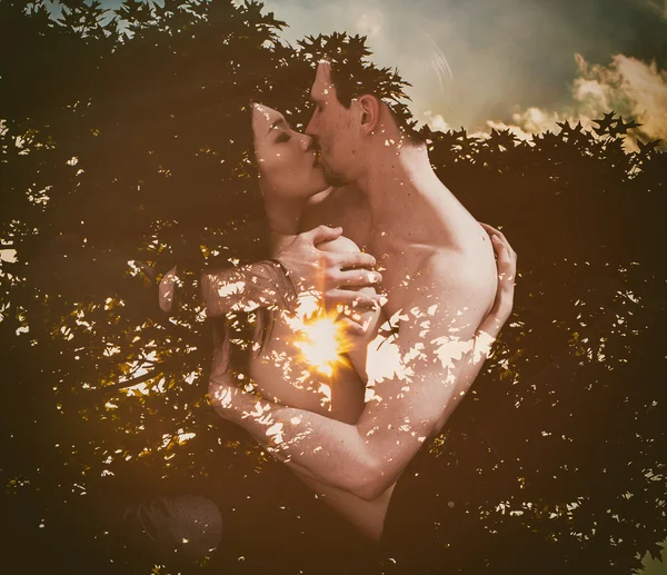 Doble exposición de amantes besándose y silueta de árbol a la luz del sol — Foto de Stock