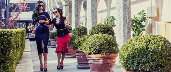 Beautiful and elegant women walking and talking near colonnade letterbox — Stock Photo, Image