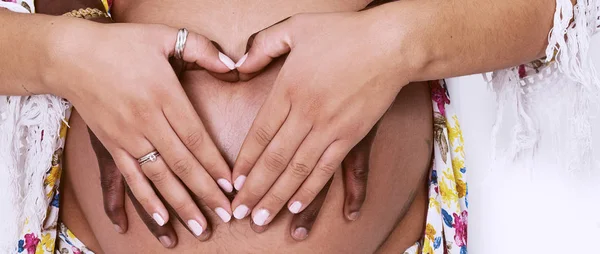 Mãos de casal segurando a barriga grávida com forma de coração caixa de correio — Fotografia de Stock