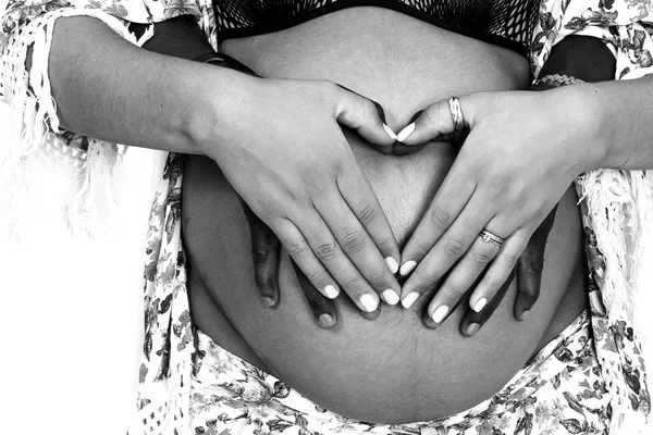 Couple hands holding together pregnant belly with heart shape monochrome — Stock Photo, Image