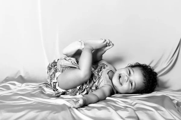 Bonito bebê menina retrato rindo enquanto mentiu preto e branco — Fotografia de Stock