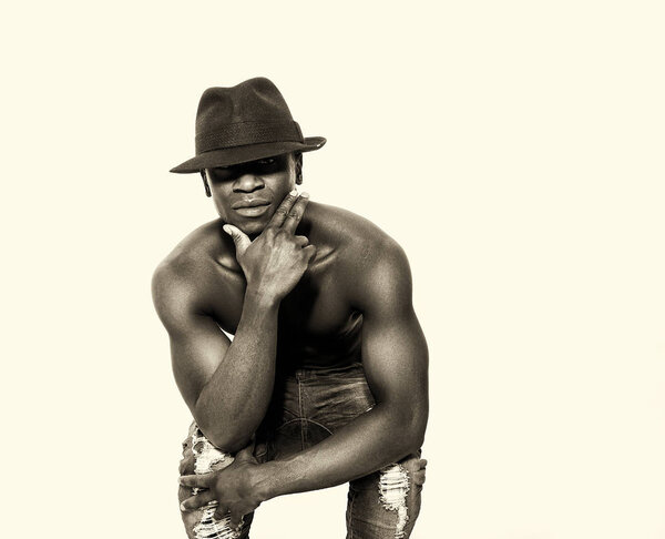 Bare-chested handsome african man portrait posing while wearing hat
