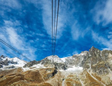 Karlı dağ ve teleferik görülen bulutlu gökyüzü