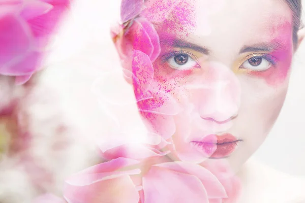 Doppia esposizione di ragazza con trucco colorato e fiori rosa — Foto Stock