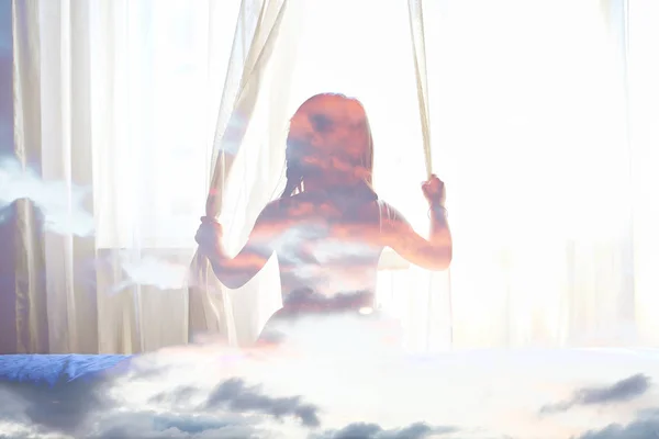 Подвійна експозиція дівчини, що дивиться у вікно та хмари заходу сонця — стокове фото