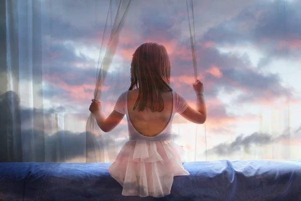 Подвійна експозиція маленької дівчинки, що дивиться у вікно і хмари — стокове фото