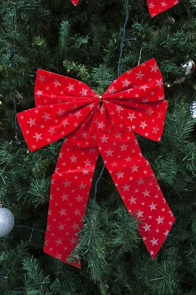 Rote Schleife mit silbernen Sternen am Weihnachtsbaum — Stockfoto