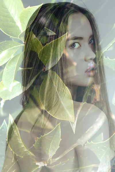 Double exposition de magnifique fille regardant en arrière et feuilles vertes — Photo