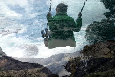 Çocuğun salıncak ve fırtınalı deniz manzarası üzerinde çift pozlama