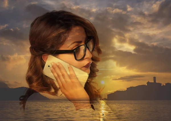 Doble exposición de la mujer de negocios en la llamada telefónica y puesta de sol del paisaje marino —  Fotos de Stock