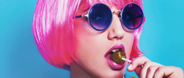 Menina pop usando peruca e óculos de sol enquanto come pirulito caixa de correio — Fotografia de Stock