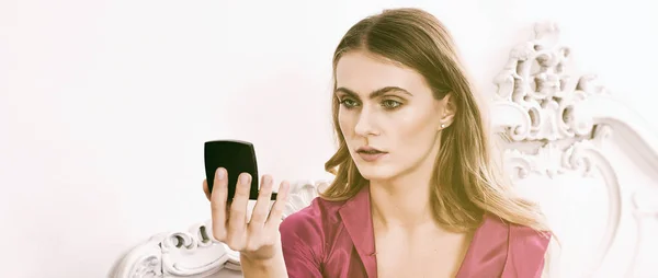 Woman looking at herself in mirror while applying makeup letterbox — Stock Photo, Image