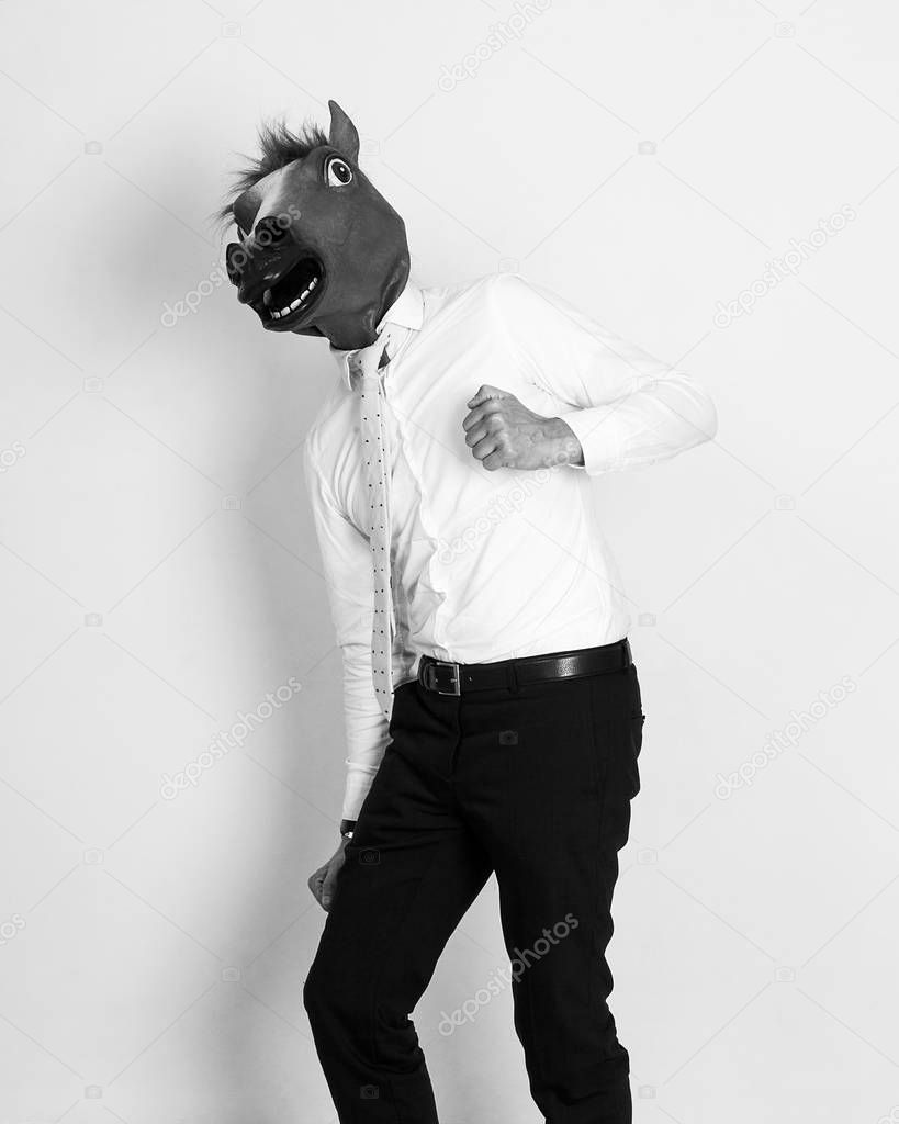 Businessman funny portrait wearing horse head and running monochrome