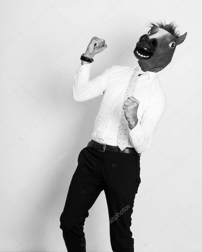 Cheerful and successful businessman portrait wearing horse head monochrome