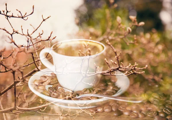 Double exposure of cup of coffee and autumn tree branches