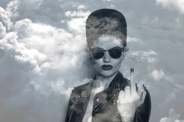 Dubbel exponering av rocker tjej iklädd solglasögon och stormiga molnlandskap — Stockfoto