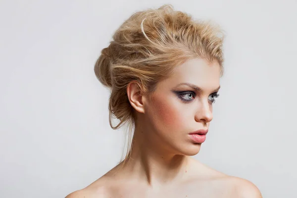 Vacker blond flicka stående med underbara blå ögon tittar åt sidan — Stockfoto