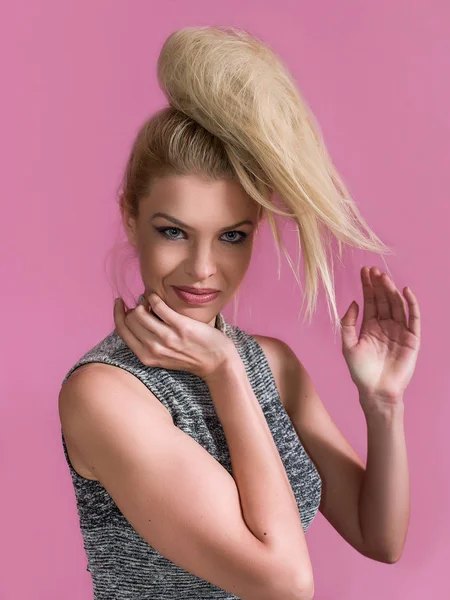 Pretty blonde girl with messy hair bun posing and smiling