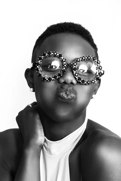 Africká dívka líbání tvář, zatímco nosí legrační brýle jednobarevné — Stock fotografie