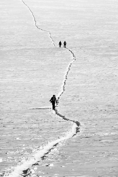 Gente caminando por el camino en la nieve en blanco y negro — Foto de Stock