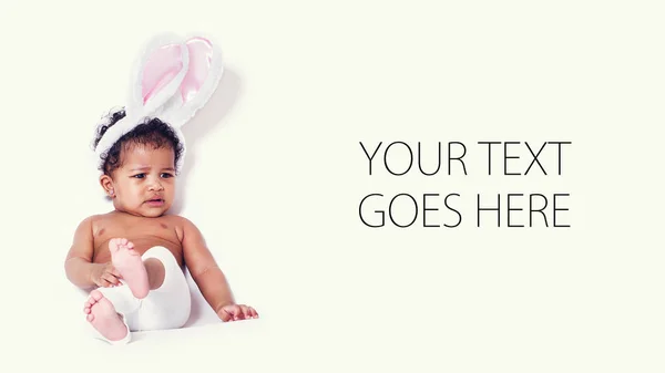 Bebê menina retrato sentado e vestindo orelhas de coelho, cartão — Fotografia de Stock
