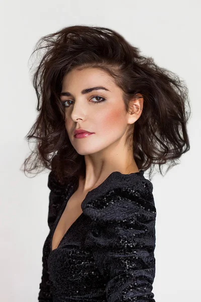 Hübsche Frau mit unordentlichem Haar posiert im schwarzen Paillettenkleid — Stockfoto