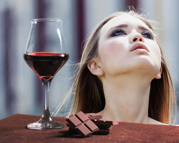 Copa de vino tinto con chocolate y retrato de chica bonita mirando hacia arriba — Foto de Stock