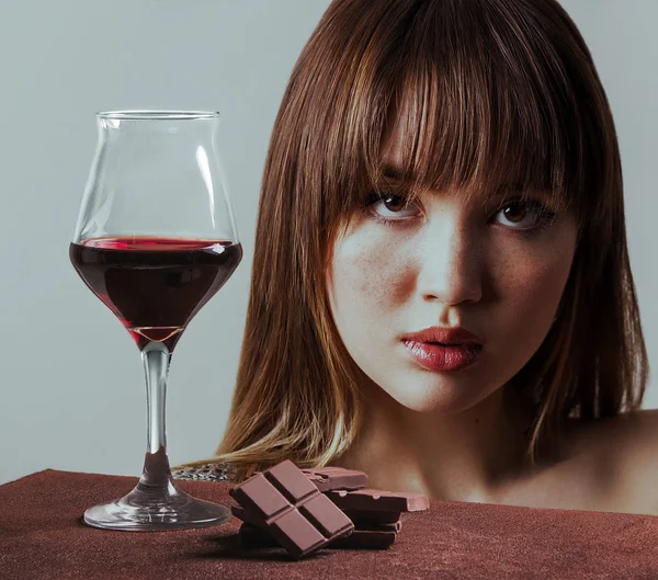 Copa de vino tinto con chocolate y chica encantadora con pecas — Foto de Stock