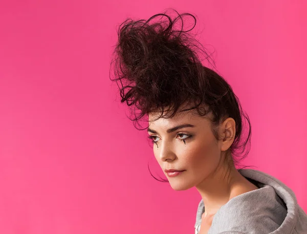 Pretty woman portrait with messy bun wearing hoodie and looking aside — Stock Photo, Image