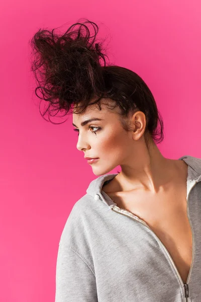 Sensuell kvinna porträtt med messy bun bär hoodie och tittar åt sidan — Stockfoto