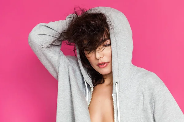 Retrato de mulher com cabelo bagunçado usando capuz cinza — Fotografia de Stock