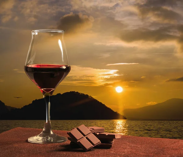 Ποτήρι κόκκινου κρασιού τύπου με σοκολάτα και όμορφο ηλιοβασίλεμα στη λίμνη Iseo — Φωτογραφία Αρχείου