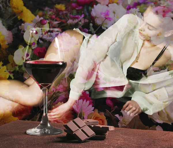 Rode wijnglas met chocolade en meisje liggend met kleurrijke bloemen — Stockfoto
