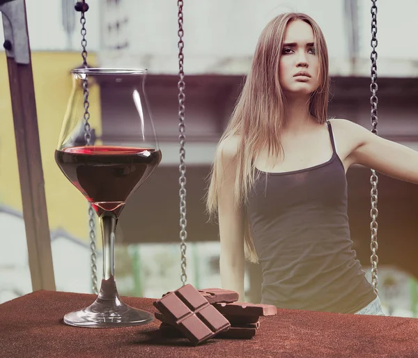 Red wine glass with chocolate and beautiful girl in the playground — Stock Photo, Image