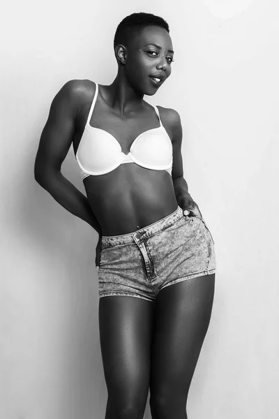 Beautiful african girl monochrome portrait wearing jeans shorts and smiling — Stock Photo, Image