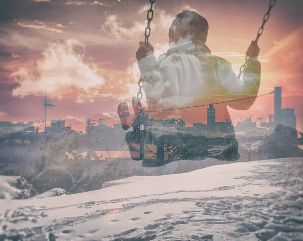 Multiexponering killen på swing och stadens silhuett med snowy Mountains — Stockfoto