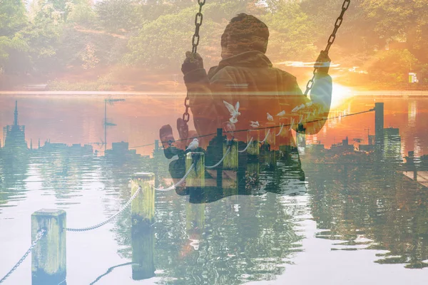 Multiple exposure of kid on swing and cityscape with lakescape and gulls — Stock Photo, Image