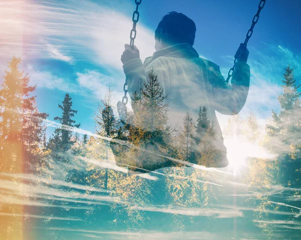 Múltipla exposição da criança no balanço e floresta de pinheiros com nebulosidade azul — Fotografia de Stock