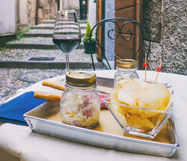 Mesa de restaurante italiana con aperitivos y copa de vino tinto — Foto de Stock