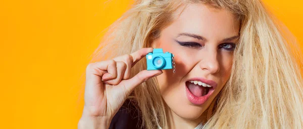 Mooi meisje portret holding mini toy camera en knipogen, brievenbus — Stockfoto