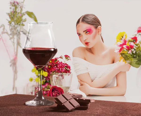 Copa de vino tinto con chocolate y retrato de mujer bonita con flores — Foto de Stock