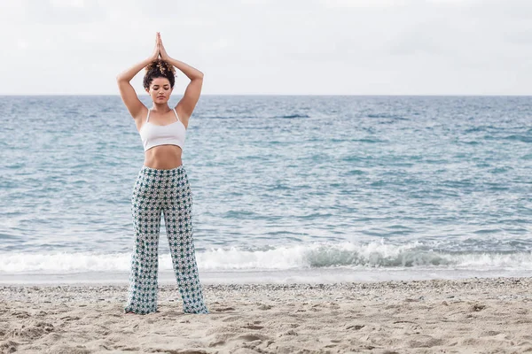 Schöne und entspannte Frau beim Yoga am Strand — Stockfoto