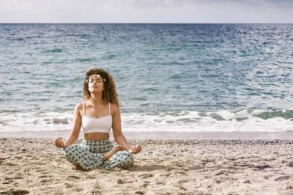 Schöne Frauenporträt sitzt am Strand und meditiert — Stockfoto