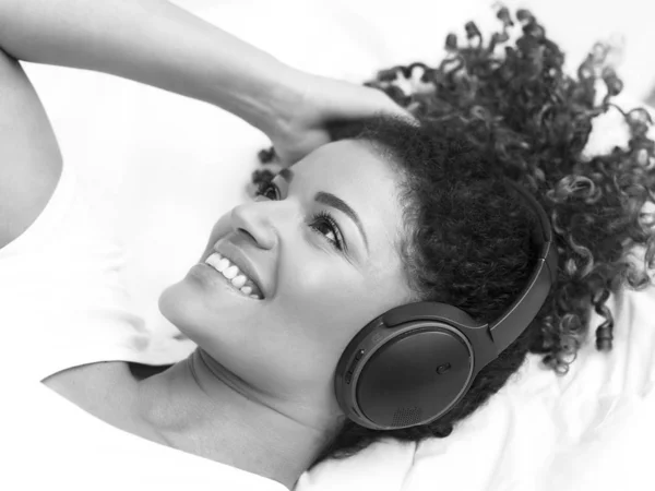 Gorgeous and happy woman portrait relaxing while listening to music, monochrome — Stock Photo, Image