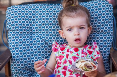 Sarma yemek ve oturma sevimli küçük kız portre