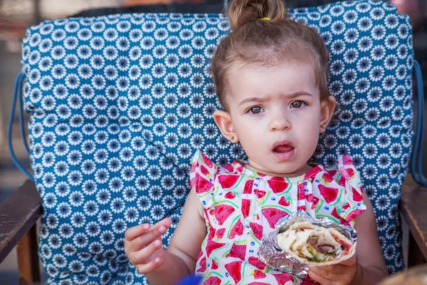 Sarma yemek ve oturma sevimli küçük kız portre